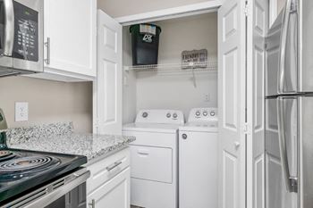 The kitchen features granite counters and the laundry closet.
